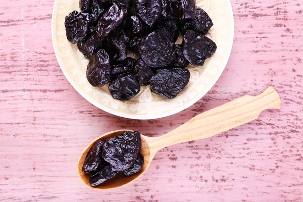 Bowl and spoon of prunes — Stock Photo, Image