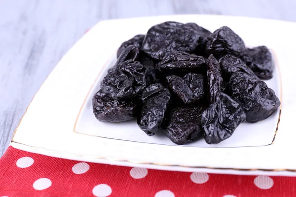 Squared white plate of prunes — Stock Photo, Image