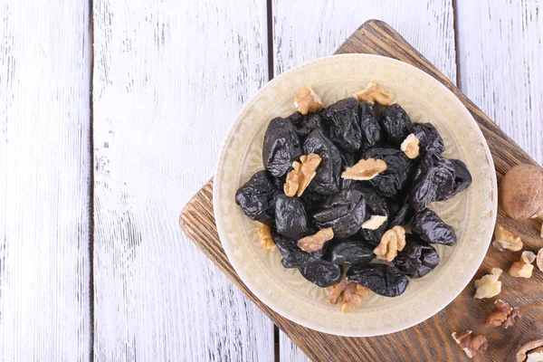 Plate of prunes and walnuts — Stock Photo, Image