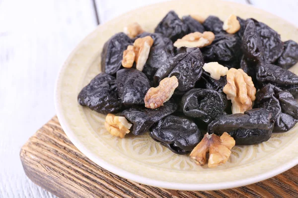 Plate of prunes and walnuts — Stock Photo, Image