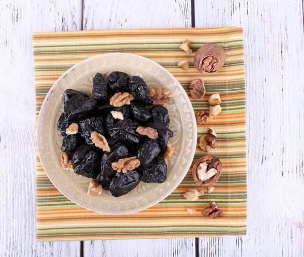 Plate of prunes and walnuts — Stock Photo, Image