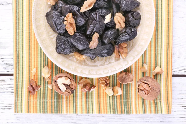 Plate of prunes and walnuts — Stock Photo, Image