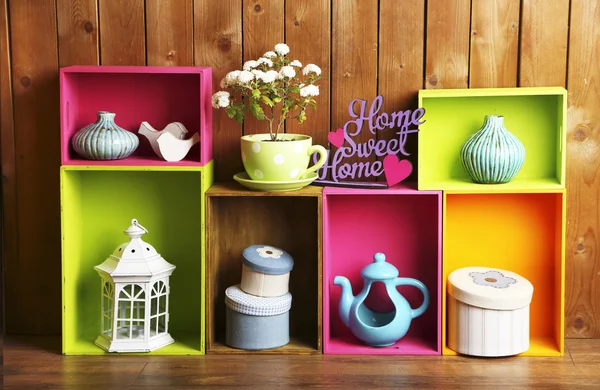 Piękne kolorowe półki z różnych obiektów związanych z domu na tle ściany drewniane — Zdjęcie stockowe