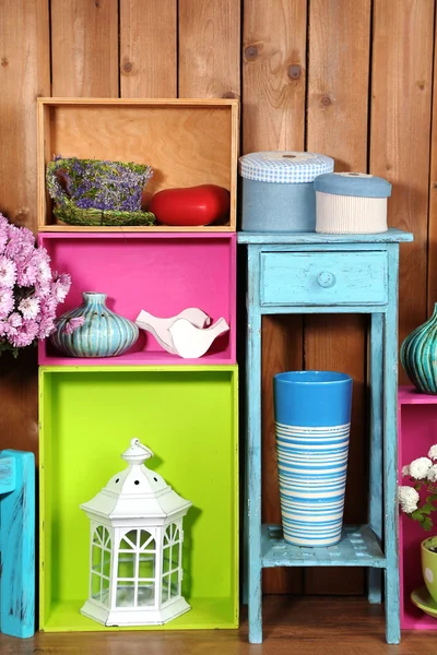 Beautiful colorful shelves with different home related objects on wooden wall background — Stock Photo, Image