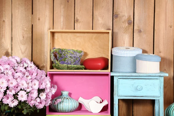 Красиві барвисті полиці з різними предметами, пов'язаними з будинком на дерев'яному тлі стін — стокове фото
