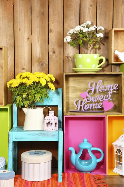 Beautiful colorful shelves with different home related objects on wooden wall background — Stock Photo, Image