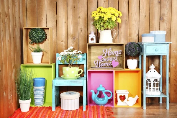 Beautiful colorful shelves with different home related objects on wooden wall background — Stock Photo, Image