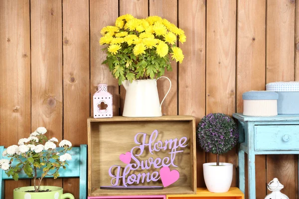 Beautiful colorful shelves with different home related objects on wooden wall background — Stock Photo, Image