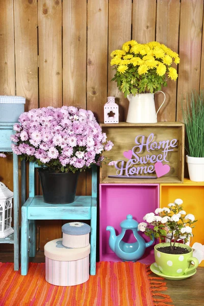 Beautiful colorful shelves with different home related objects on wooden wall background — Stock Photo, Image