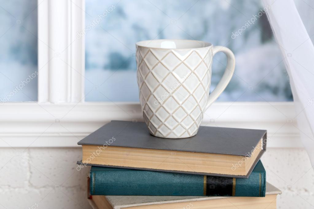 Books and cup on the windowsill