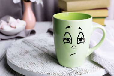 Emotional cup on wooden table clipart