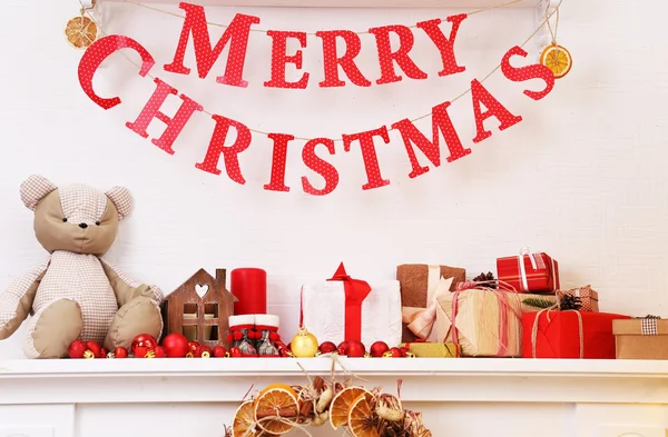Decorațiuni de Crăciun pe mantelpiece pe fundal de perete alb — Fotografie, imagine de stoc
