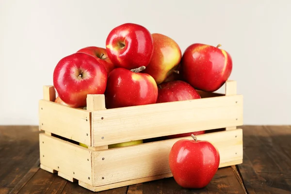 Caixa de maçãs na mesa de madeira — Fotografia de Stock