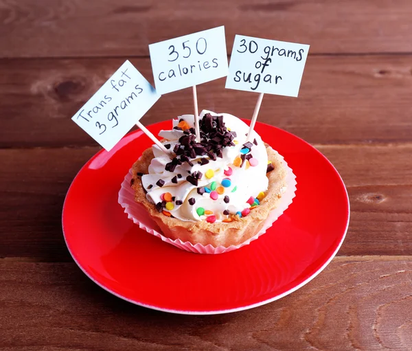 Deliziosa torta con calorie contare le etichette sul piatto di colore su sfondo tavolo di legno — Foto Stock