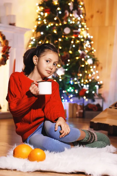 Menina bonito com leite perto da árvore de Natal — Fotografia de Stock