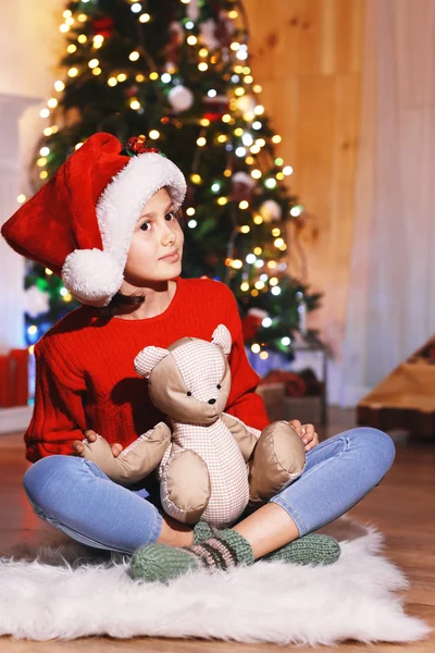 Menina bonito com brinquedo esperando noite de Natal — Fotografia de Stock