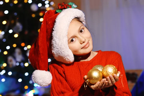 Söt liten flicka i Santa hatt dekorera julgran — Stockfoto