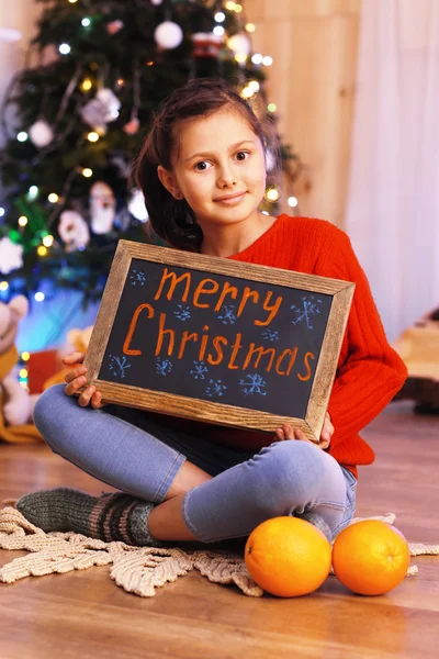 Niedliches kleines Mädchen mit Gruß frohe Weihnachten — Stockfoto