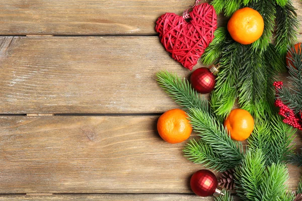 Fresh ripe mandarins, Christmas decorations and fir tree bud on wooden background — Stock Photo, Image