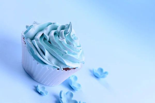 Delicioso cupcake no fundo azul — Fotografia de Stock