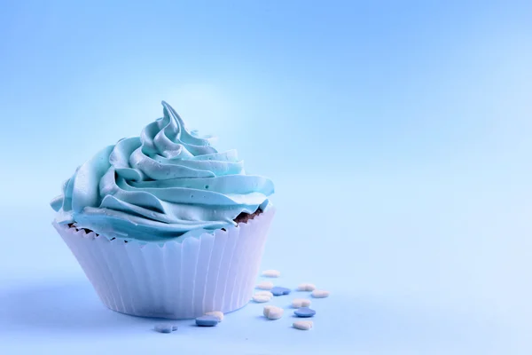 Вкусный кекс на голубом фоне — стоковое фото