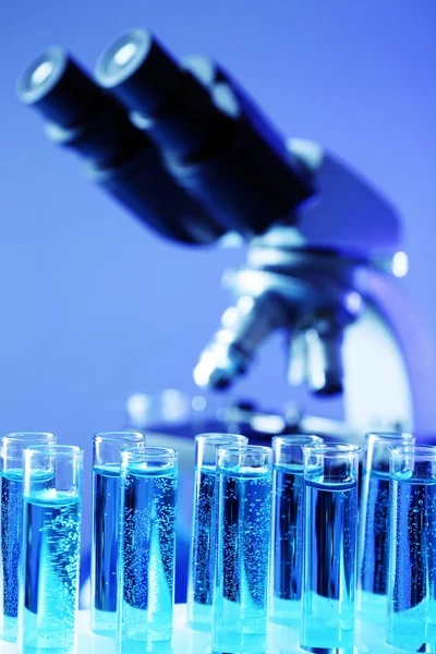 Test tubes on microscope background — Stock Photo, Image