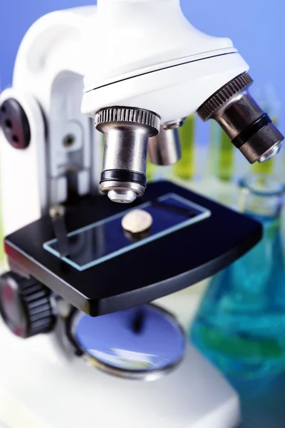 Microscope and laboratory sample, close-up on color background — Stock Photo, Image