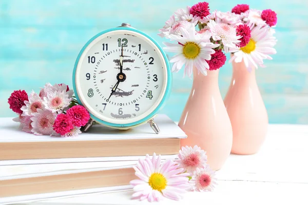 Vackra blommor i vaser på bordet på ljusblå bakgrund — Stockfoto