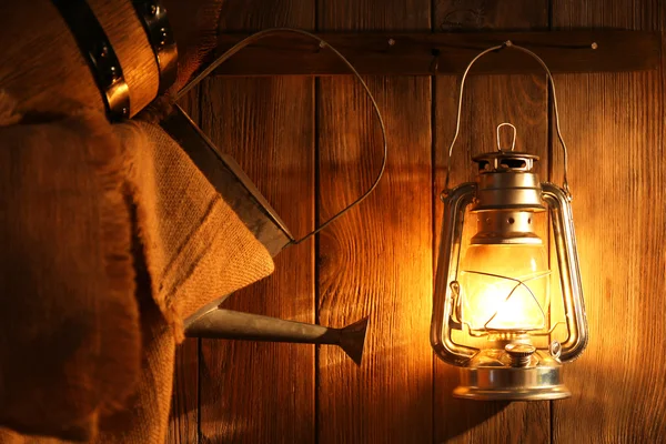 Lantern hanging on hook on wooden wall — Stock Photo, Image