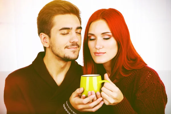 Loving couple with hot drink — Stock Photo, Image