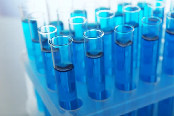 Blue water in a transparent test-tube on light background — Stock Photo, Image