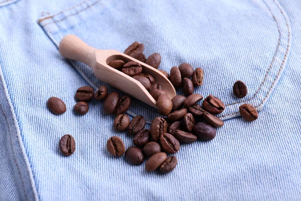 Szufelka z ziaren kawy na tle dżinsy — Zdjęcie stockowe