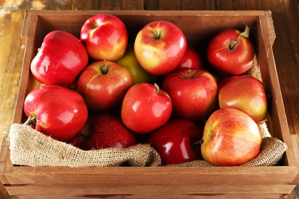 Red apples in wooden crate with burlap cloth — Stock Photo, Image