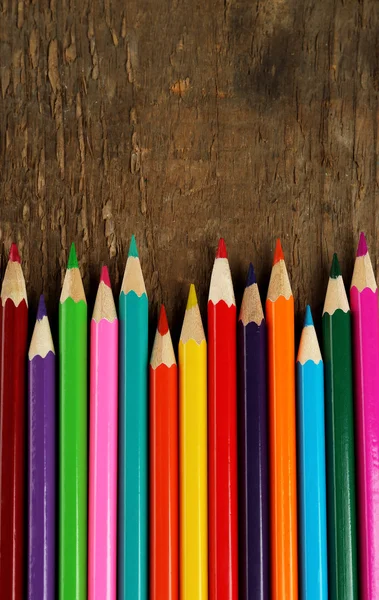 Lápices de colores sobre fondo rústico de madera — Foto de Stock