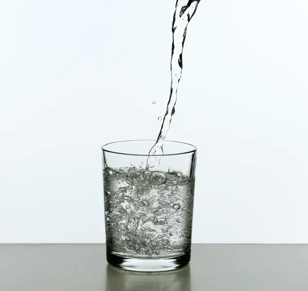 Wasser aus der Flasche gießen — Stockfoto