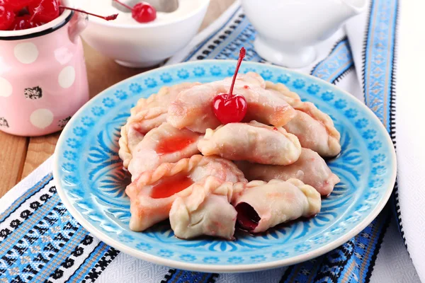 Vareniki with cherry on plate on tablecloth close-up — Stock Photo, Image