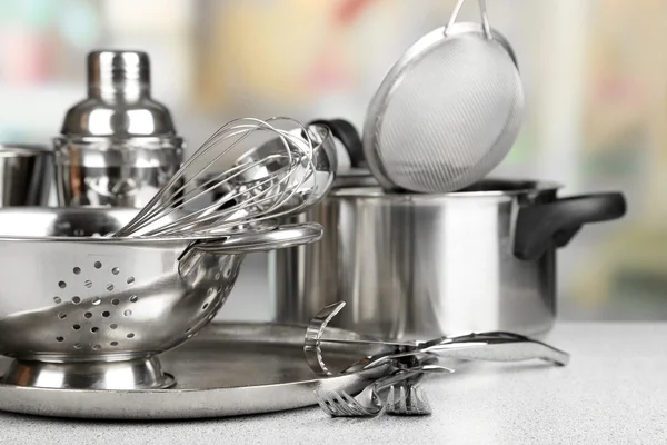 Кухонные принадлежности из нержавеющей стали на столе — стоковое фото