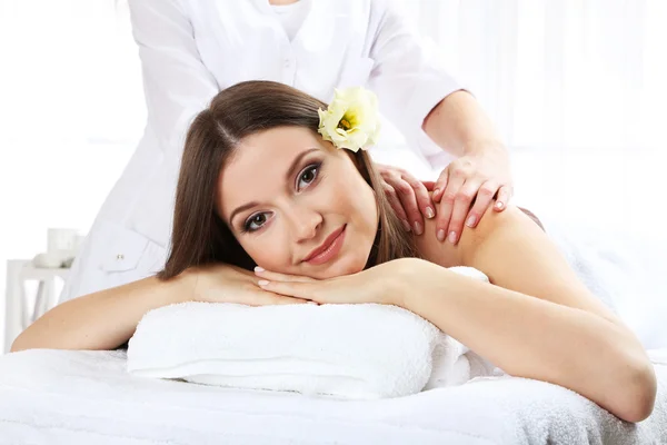 Schöne junge Frau mit Massage im Wellness-Salon — Stockfoto