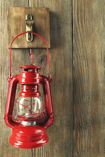 Lantern hanging on hook on wooden wall — Stock Photo, Image