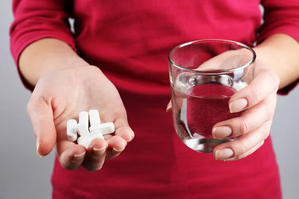 Mains avec des pilules et de l'eau — Photo