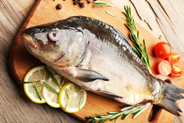 Verse rauwe vis en voedselingrediënten op tafel — Stockfoto