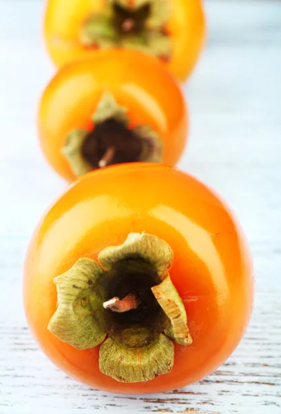 Ripe persimmons on wooden background — Stock Photo, Image