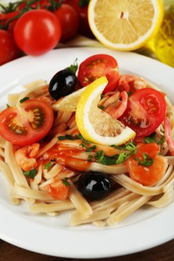 Lezzetli makarna karides, midye, Siyah Zeytin ve ahşap arka plan üzerinde tabakta domates sosu ile