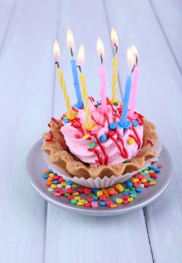 Doğum günü kek uçan daire mum ve renk ahşap arka plan üzerinde parıldıyor