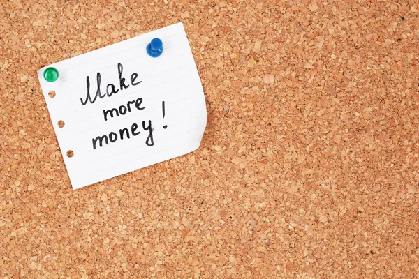 Paper sheet with inscription "Make more money" on wooden background — Stock Photo, Image