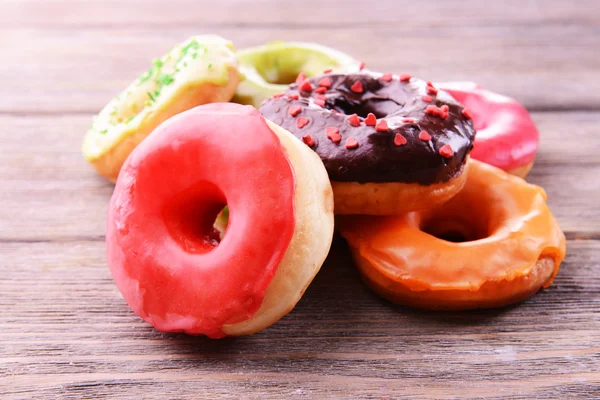 Deliciosos donuts com esmalte na mesa close-up — Fotografia de Stock