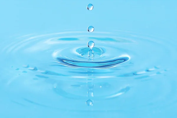 Drop in blauwe water — Stockfoto