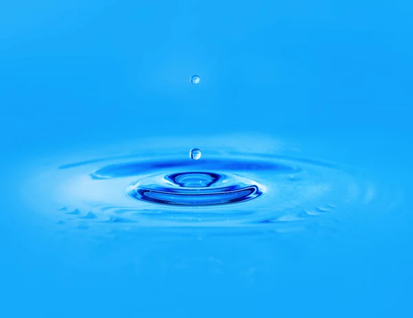 Drop in blauwe water — Stockfoto