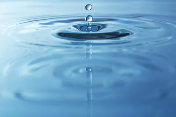 Tropfen im blauen Wasser — Stockfoto