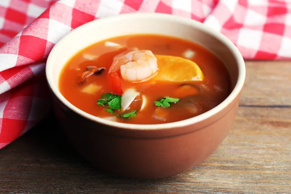 木製の背景にボウルにエビとムール貝のおいしいスープ — ストック写真